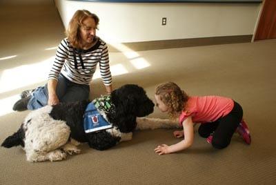 Laure Seiber and her therapy dog Charlie work with a child at the Barber National Institute in Erie, Pa.